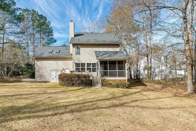 rear view of house featuring a lawn and a sunroom