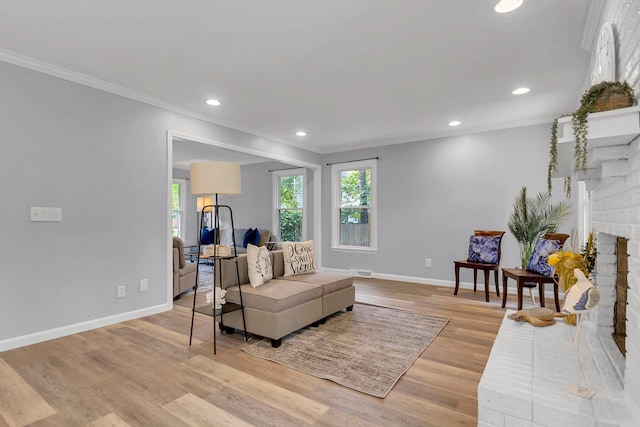 sitting room with light wood-type flooring, a fireplace, and ornamental molding