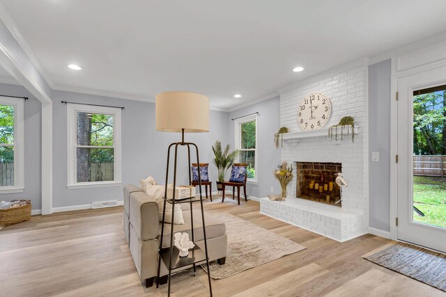 dining area featuring hardwood / wood-style flooring, a brick fireplace, and a healthy amount of sunlight