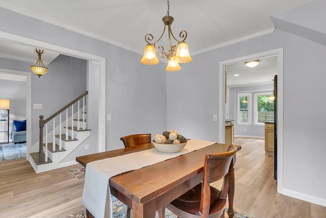 dining area with ornamental molding, light hardwood / wood-style flooring, and a chandelier