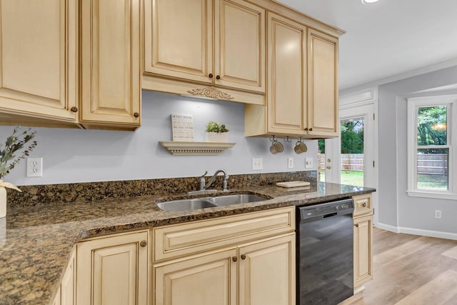 kitchen with dark stone countertops, black dishwasher, light hardwood / wood-style floors, and sink