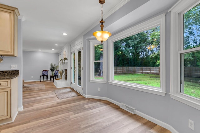 unfurnished dining area with light hardwood / wood-style floors and ornamental molding