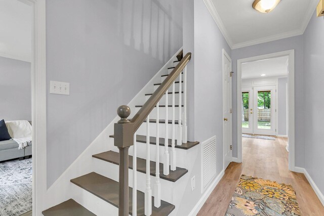 staircase featuring hardwood / wood-style flooring and crown molding