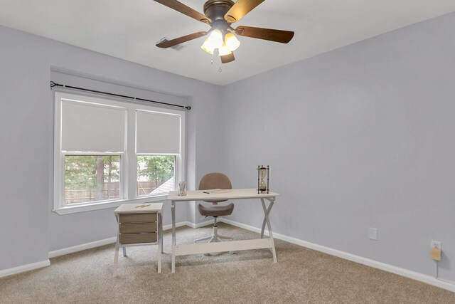 carpeted office space with ceiling fan