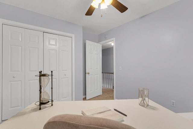 carpeted bedroom featuring ceiling fan and a closet