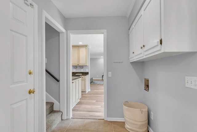 clothes washing area featuring hookup for a washing machine, cabinets, and light hardwood / wood-style flooring