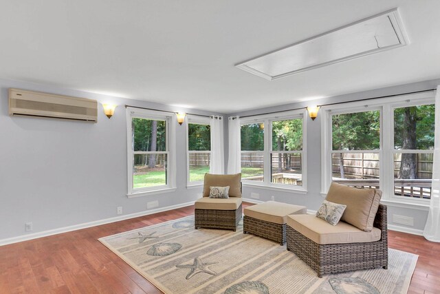 sitting room with hardwood / wood-style floors and a wall mounted air conditioner