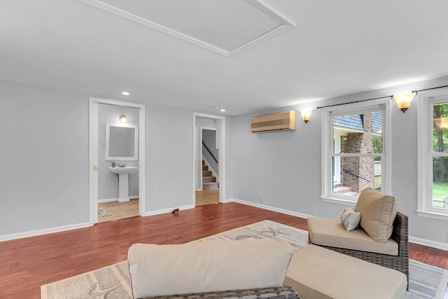 living room featuring plenty of natural light, a wall mounted AC, sink, and hardwood / wood-style floors