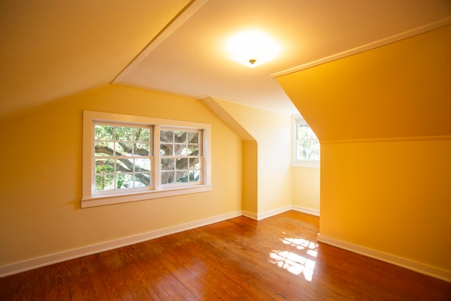 bonus room with a wealth of natural light, lofted ceiling, and hardwood / wood-style flooring