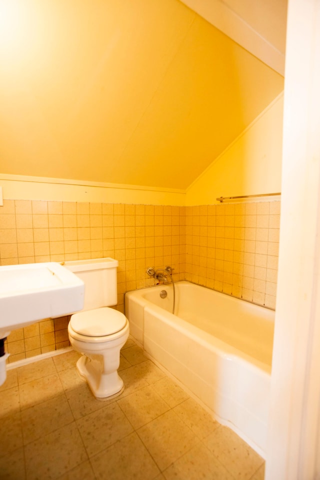 bathroom with toilet, tile walls, a washtub, and tile patterned flooring