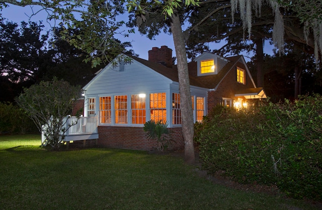 view of side of home with a yard