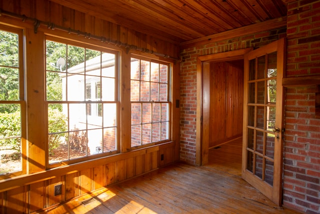 unfurnished sunroom featuring wooden ceiling and plenty of natural light