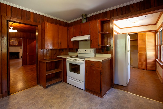 kitchen with crown molding, wooden walls, light wood-type flooring, and white appliances