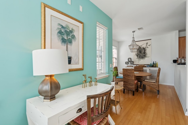 dining space with visible vents, light wood-type flooring, and baseboards