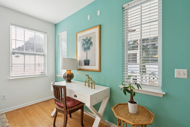 office area with baseboards and wood finished floors