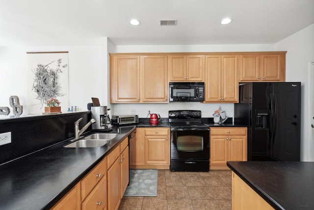 kitchen with a sink, visible vents, dark countertops, and black appliances