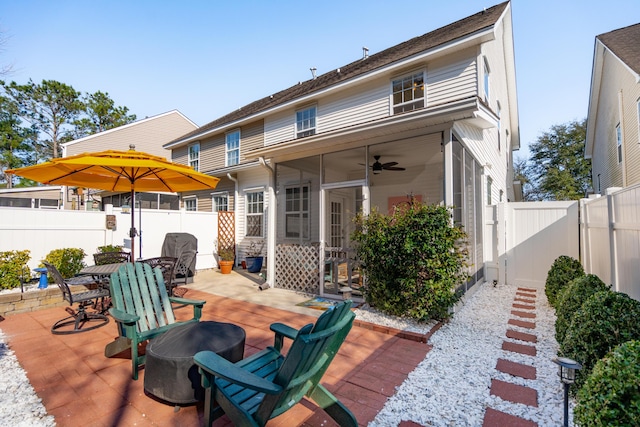 view of patio / terrace with a gate, a fenced backyard, outdoor dining space, and a sunroom