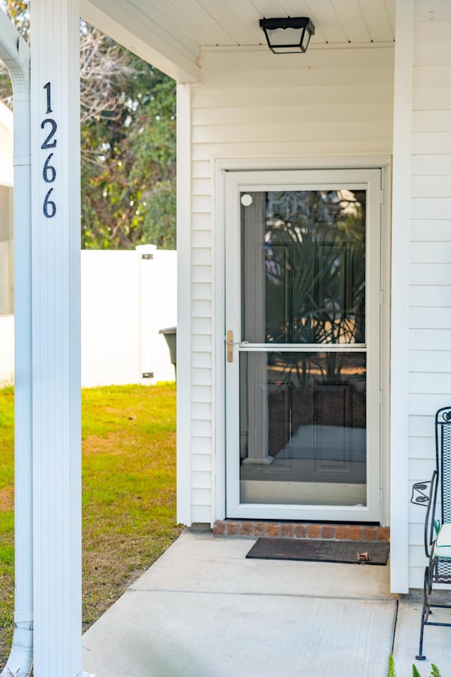 doorway to property featuring a lawn