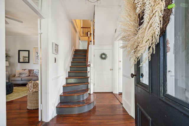 entrance foyer with ceiling fan, dark wood-type flooring, and ornamental molding