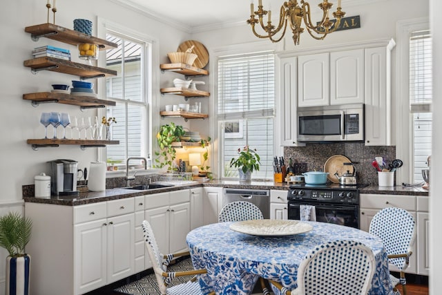 kitchen featuring decorative backsplash, stainless steel appliances, crown molding, sink, and white cabinets