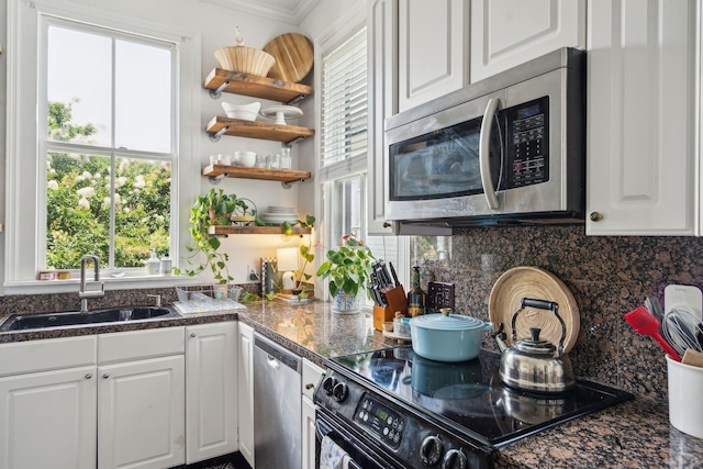 kitchen with a healthy amount of sunlight, white cabinetry, sink, and appliances with stainless steel finishes