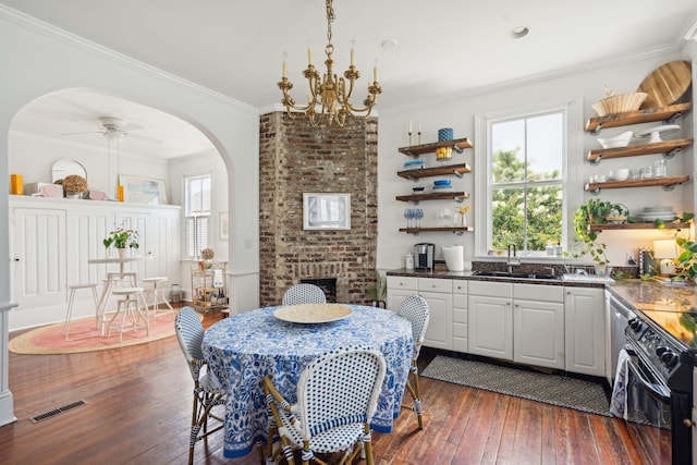 dining room with ceiling fan with notable chandelier, plenty of natural light, ornamental molding, and sink