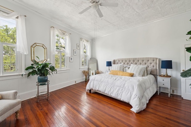 bedroom featuring ceiling fan, crown molding, dark wood-type flooring, and a textured ceiling