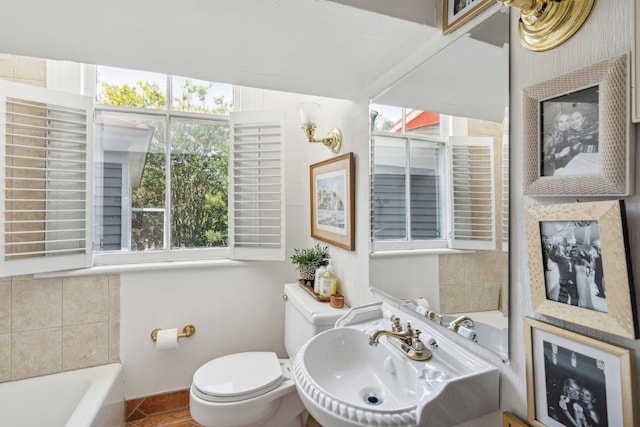 bathroom with a bath, toilet, and sink