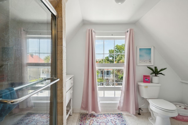 bathroom featuring tile patterned flooring, lofted ceiling, and toilet