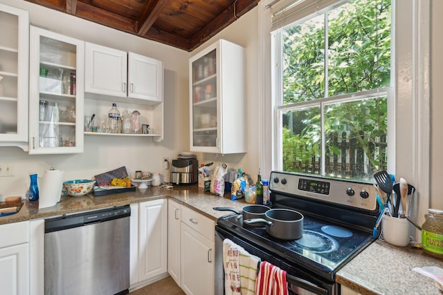 kitchen featuring white cabinets, appliances with stainless steel finishes, and dark stone countertops