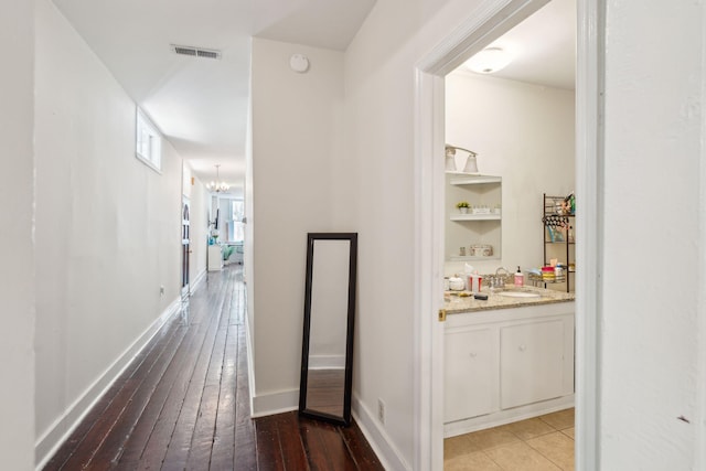 corridor featuring a chandelier, hardwood / wood-style floors, and sink