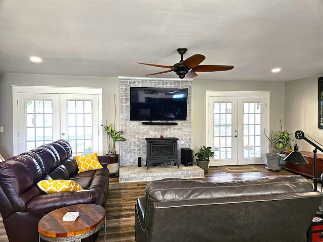 living area featuring french doors, recessed lighting, dark wood-type flooring, a wood stove, and ceiling fan