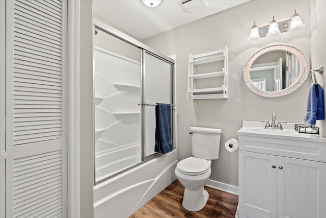 bathroom featuring a closet, visible vents, toilet, combined bath / shower with glass door, and wood finished floors