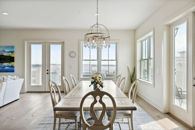 dining room featuring an inviting chandelier, light hardwood / wood-style floors, and a healthy amount of sunlight