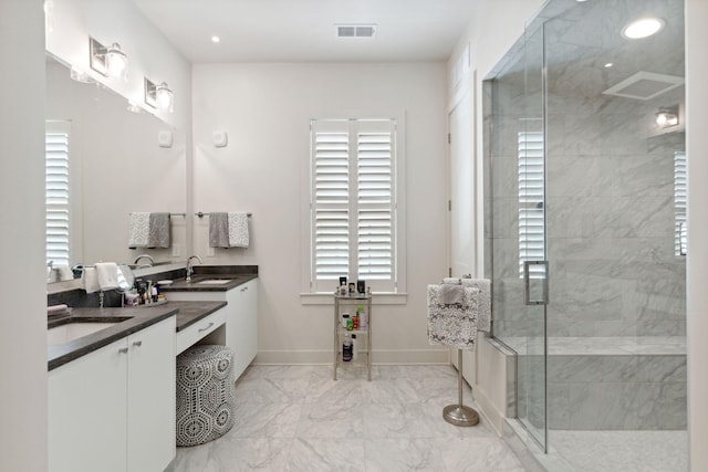 bathroom featuring a shower with door, vanity, plenty of natural light, and tile patterned floors