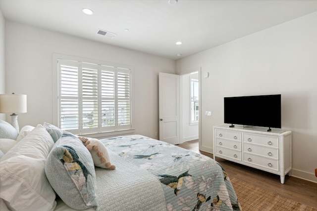 bedroom featuring multiple windows and hardwood / wood-style flooring