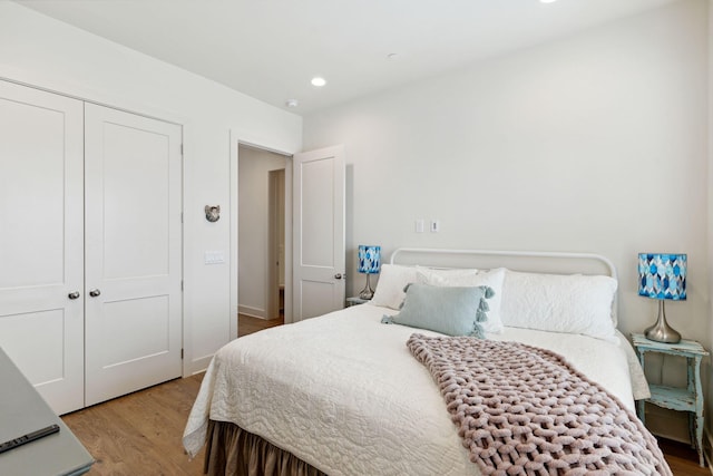 bedroom with light hardwood / wood-style flooring and a closet