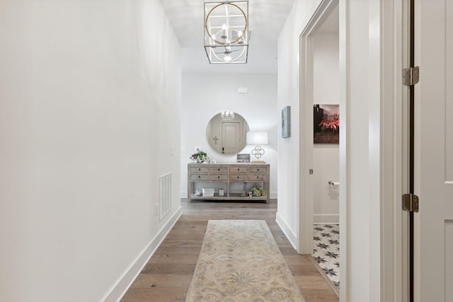 hall featuring hardwood / wood-style floors and a notable chandelier