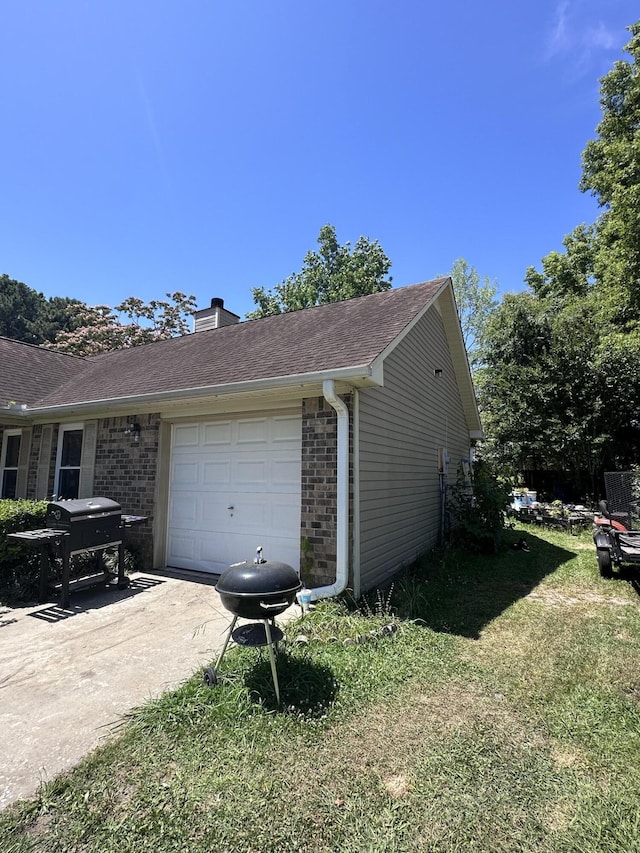 view of property exterior with a garage and a lawn