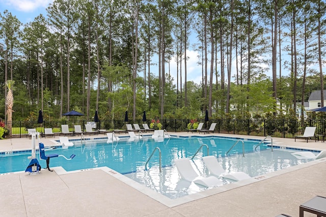 community pool featuring a patio area and fence