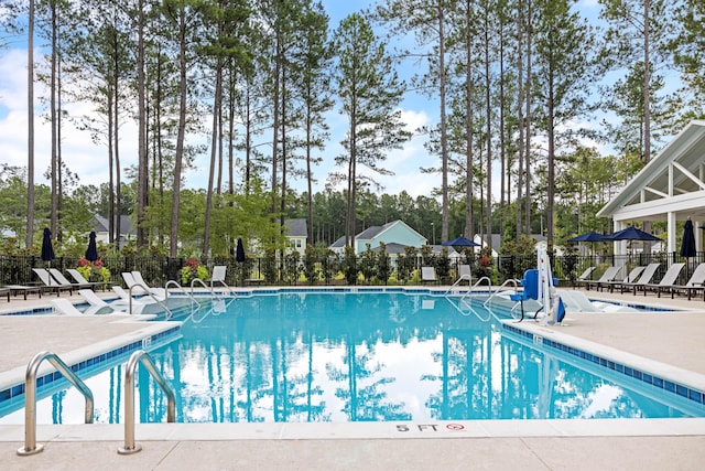 community pool with fence and a patio