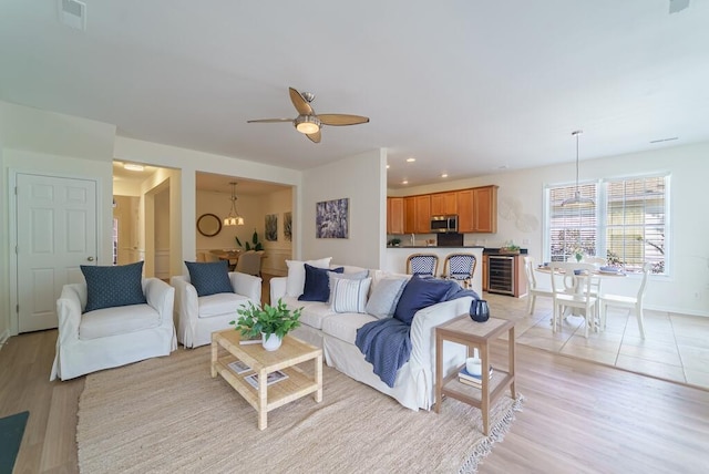 living area featuring recessed lighting, a ceiling fan, baseboards, visible vents, and light wood-style floors