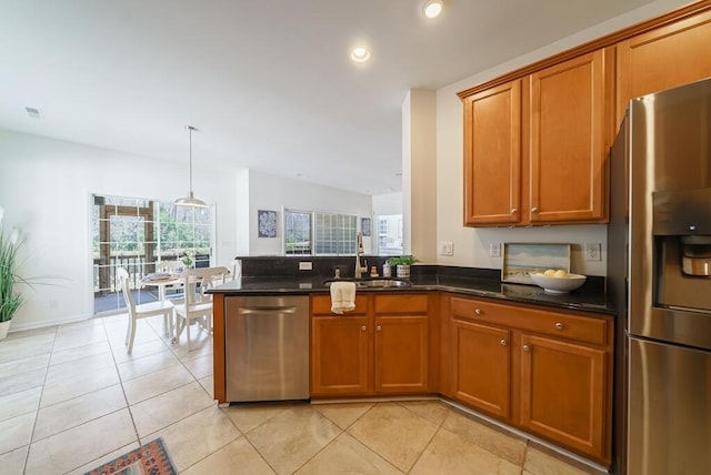 kitchen featuring appliances with stainless steel finishes, brown cabinetry, and a sink