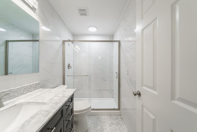 bathroom featuring visible vents, a shower stall, toilet, and vanity