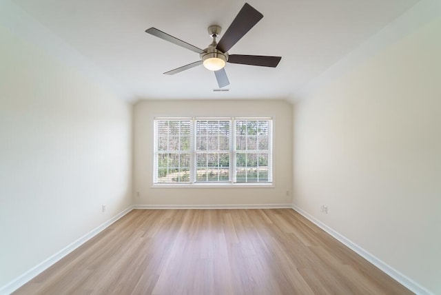 spare room with a ceiling fan, light wood-style flooring, and baseboards