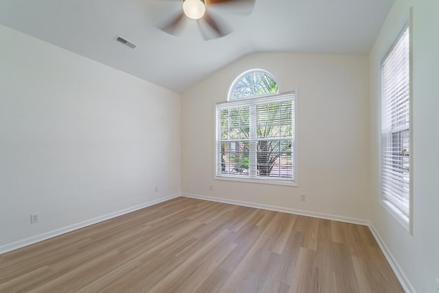 unfurnished room with baseboards, visible vents, ceiling fan, vaulted ceiling, and light wood-style floors