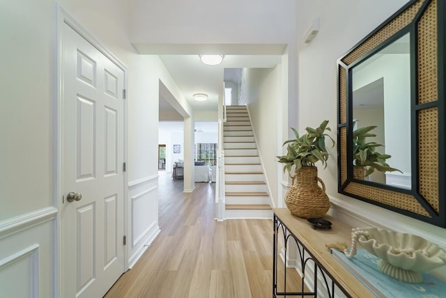 corridor featuring stairs and light wood finished floors