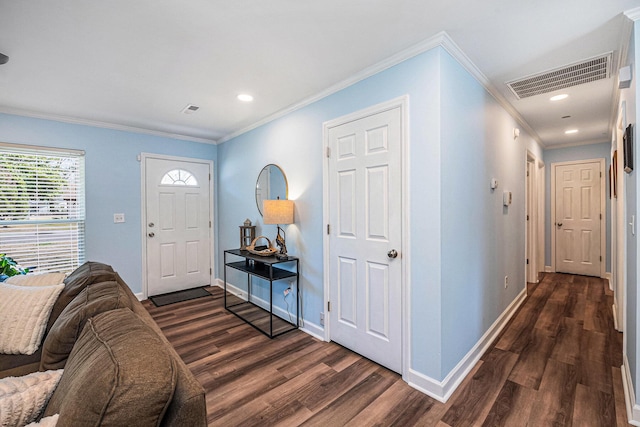 foyer entrance featuring visible vents, crown molding, baseboards, and wood finished floors