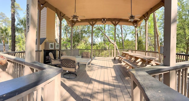 wooden terrace featuring outdoor dining space and a ceiling fan