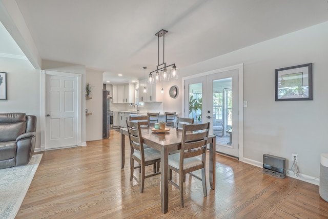 dining area with light hardwood / wood-style flooring, sink, and french doors